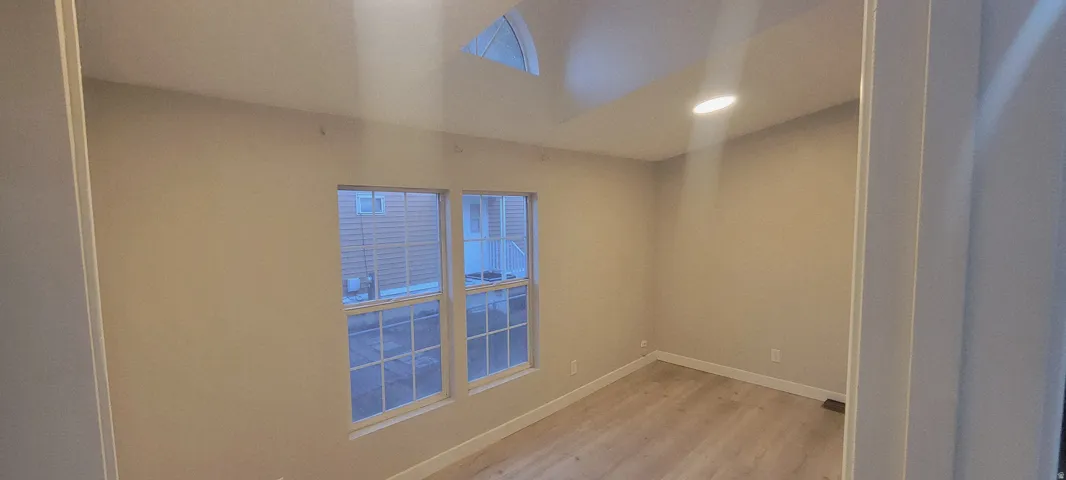 Room featuring light wood-finish flooring, neutral wall tones, and white trim