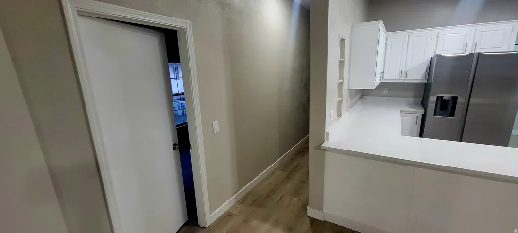 Kitchen area featuring white cabinetry, light-toned countertops, and stainless steel appliances