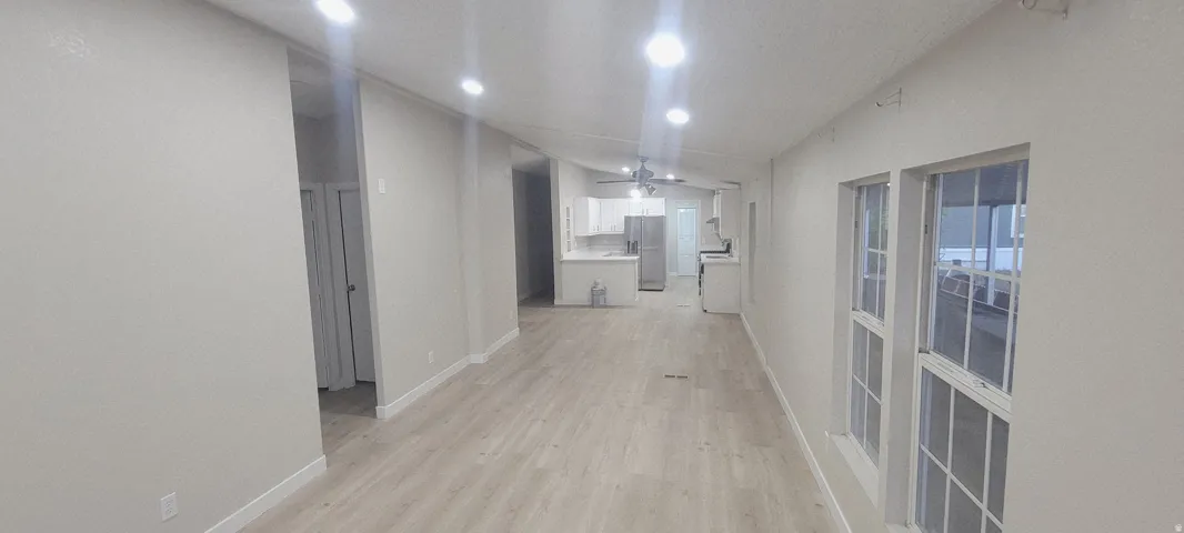Expansive interior with light wood-finish flooring, recessed lighting, and a neutral wall palette