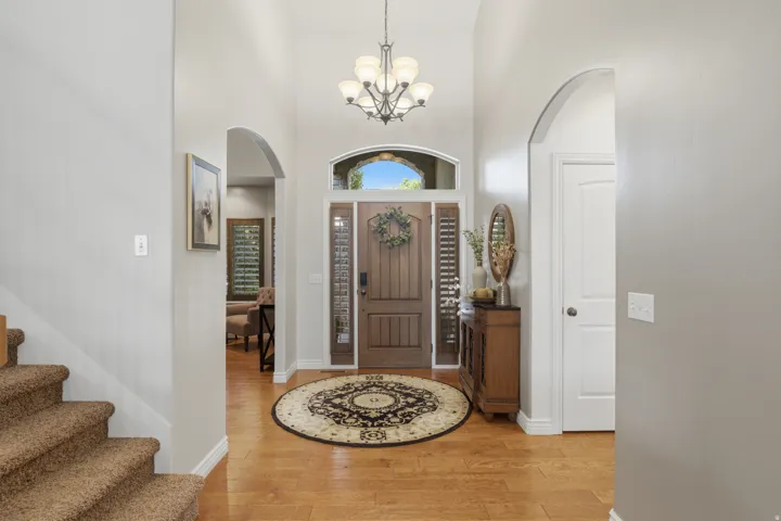 Two-story entryway with a wood-panel front door, transom window, and side lights