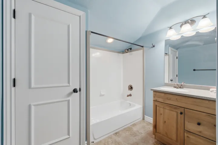 Spa-inspired bathroom featuring a wood-finish vanity with ample storage, white ceramic vessel sink, and brushed nickel fixtures