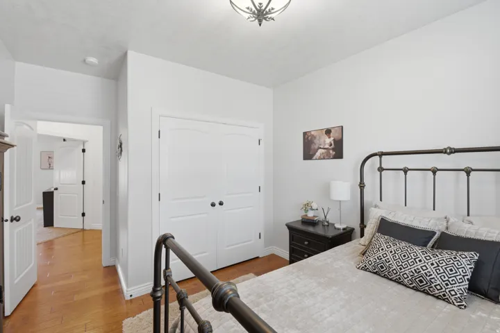 Wood-finish flooring with white baseboards, white paneled doors, and a decorative ceiling light fixture