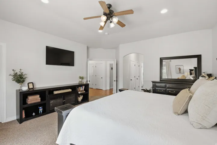 Recessed lighting, ceiling fan with light fixture, arched doorway, and built-in media console