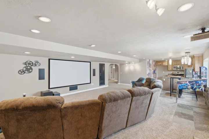 Recessed lighting illuminates the open entertainment area with a large projector screen