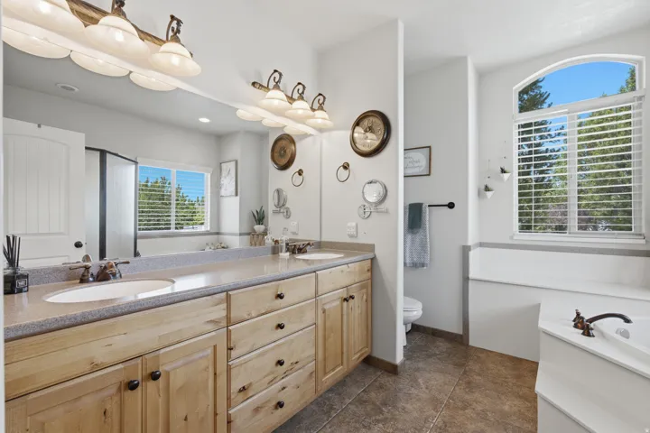 Dual vanity with light wood-finish cabinetry and integrated sinks