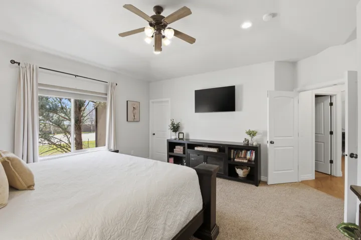 Vaulted ceiling with a ceiling fan, recessed lighting, large window, and carpeted flooring