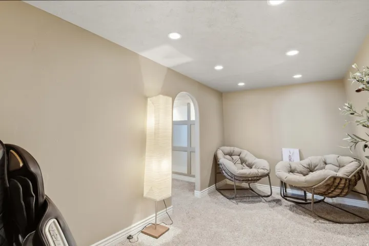 Recessed ceiling lighting, arched doorway, and neutral tone walls