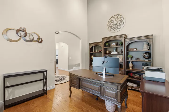 Hardwood flooring, arched doorway, vaulted ceiling, and built-in shelving
