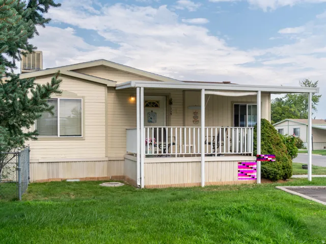 Single-story residence featuring light-colored siding and a covered front porch with white railings