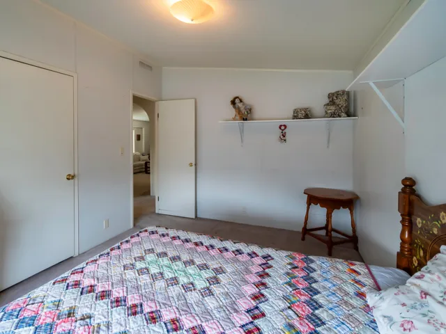 Carpeted interior space with white walls and built-in shelving