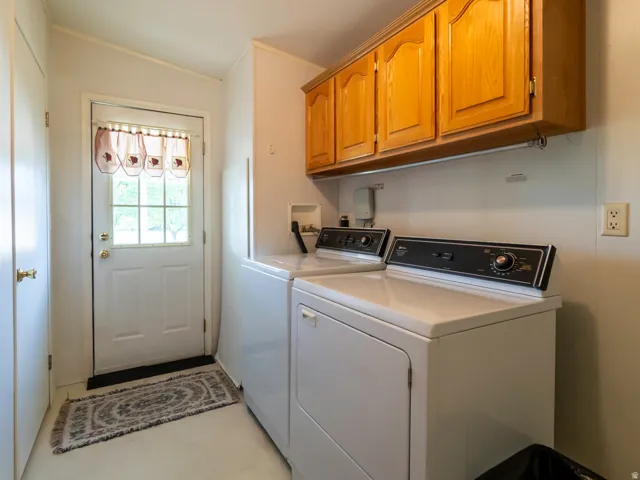 Dedicated laundry area featuring overhead wood cabinetry and a white paneled door with window