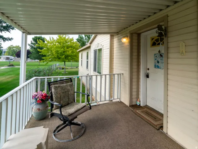 Covered porch with horizontal siding exterior, carpeted flooring, and a white railing