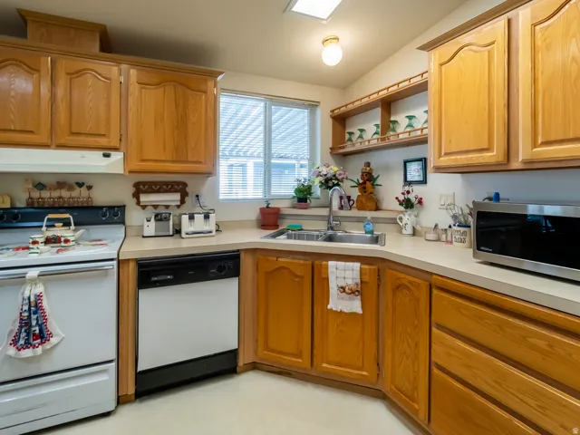 Light-toned wood-finish cabinetry with a corner sink and window