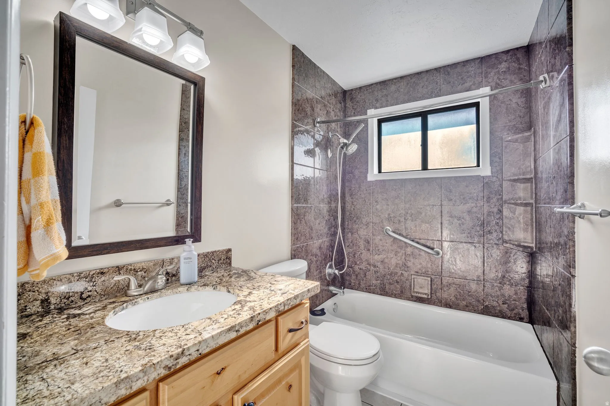 Bathroom featuring a vanity with a granite countertop and an undermount sink