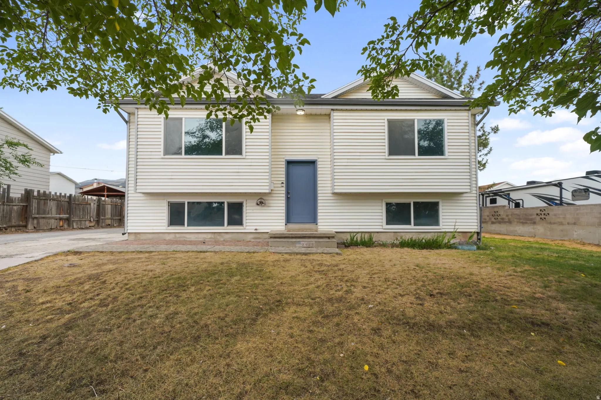 Two-story residence featuring white horizontal siding and a contrasting blue entry door