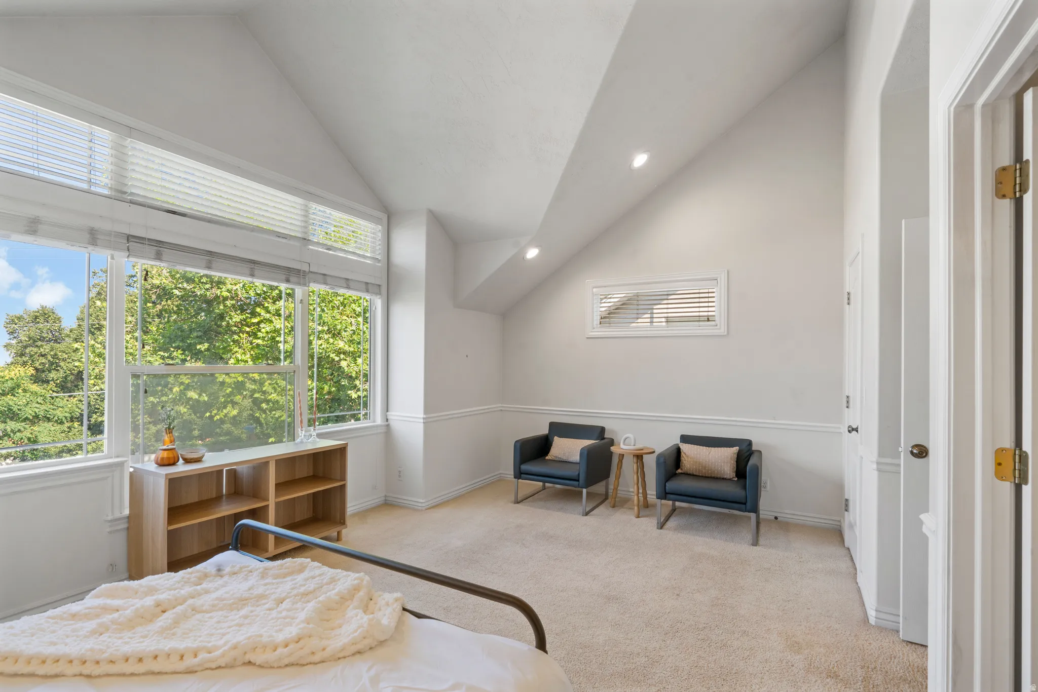 Vaulted ceiling room featuring extensive natural light from a wall of windows