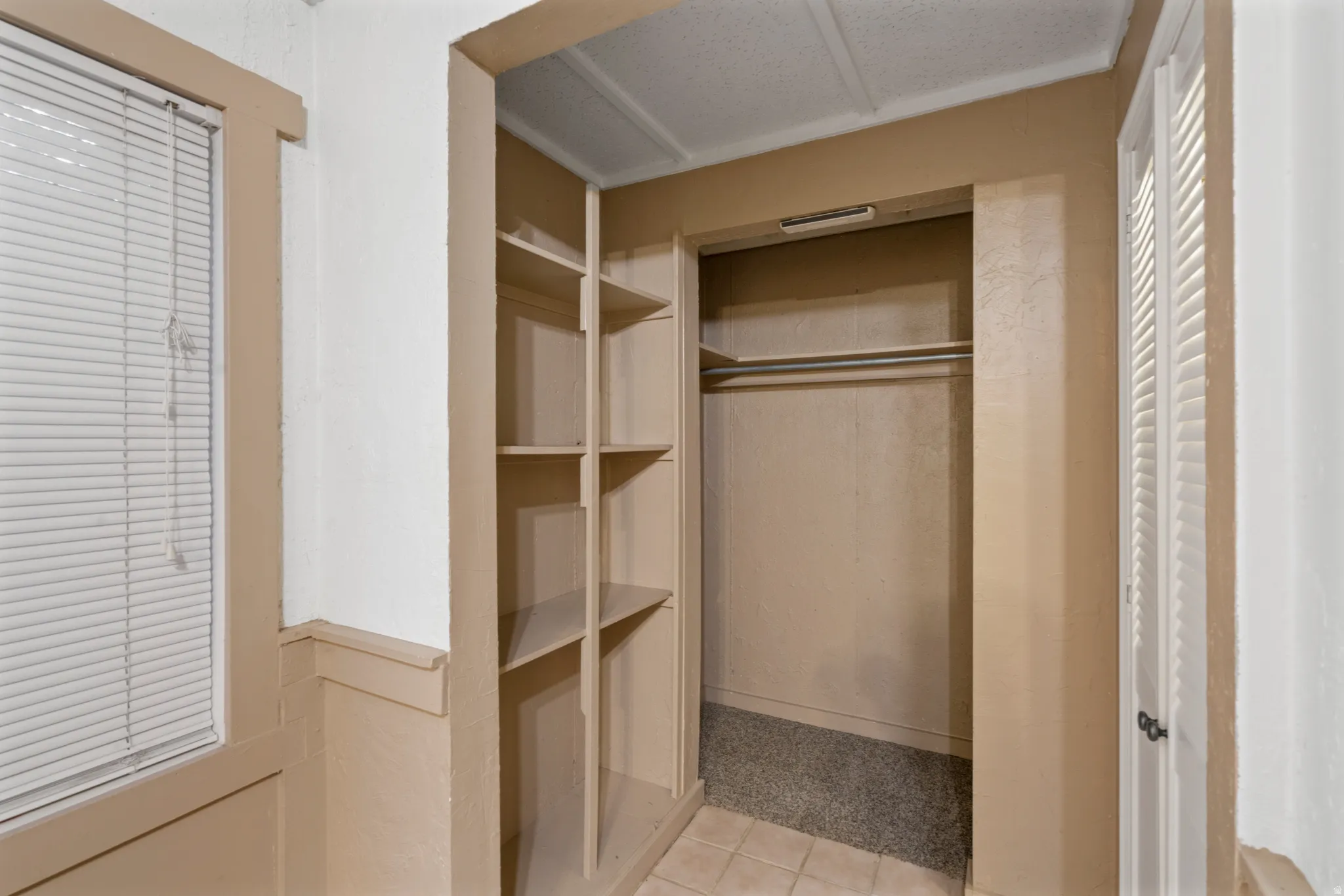 Built-in shelving unit providing storage, accompanied by a closet with a hanging rod