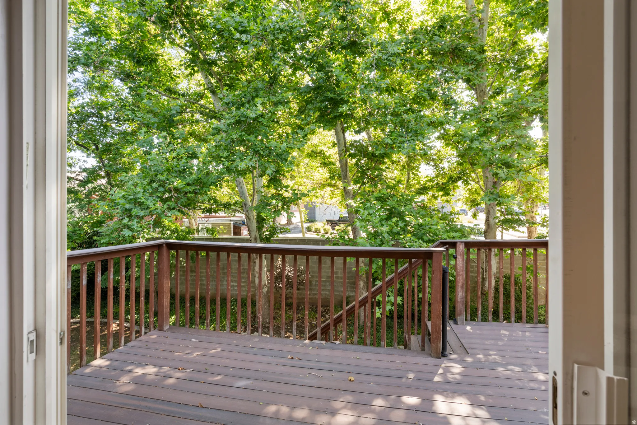 Expansive outdoor deck with a rich brown finish, featuring a surrounding railing and ample space