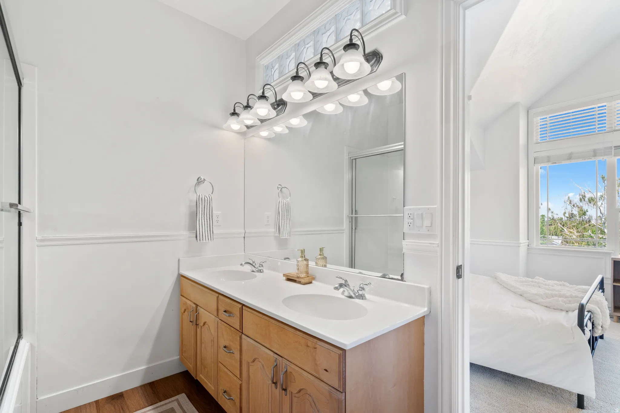 Bathroom featuring a dual vanity with a white countertop and wood-finish cabinetry
