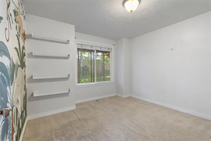 Bright room featuring neutral carpeting and white baseboards