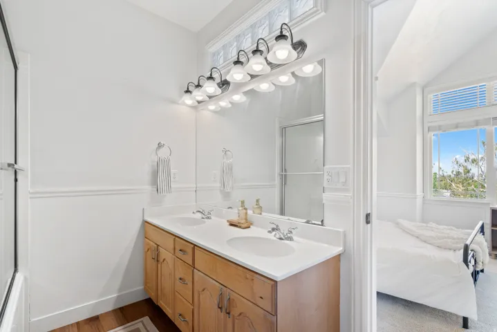 Bathroom featuring a dual vanity with a white countertop and wood-finish cabinetry