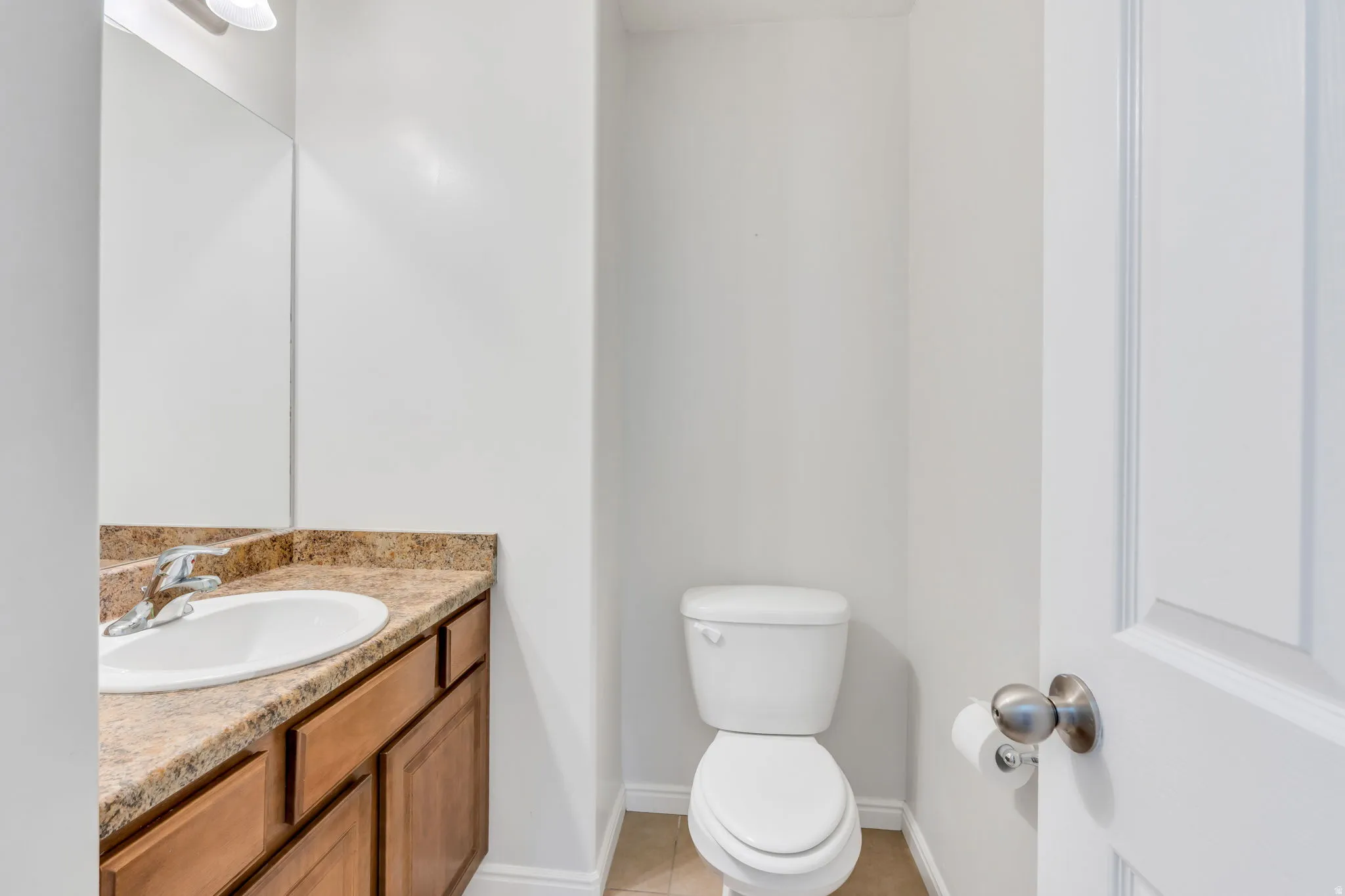Bathroom vanity with an integrated oval sink, a speckled countertop, and wood-finish cabinetry