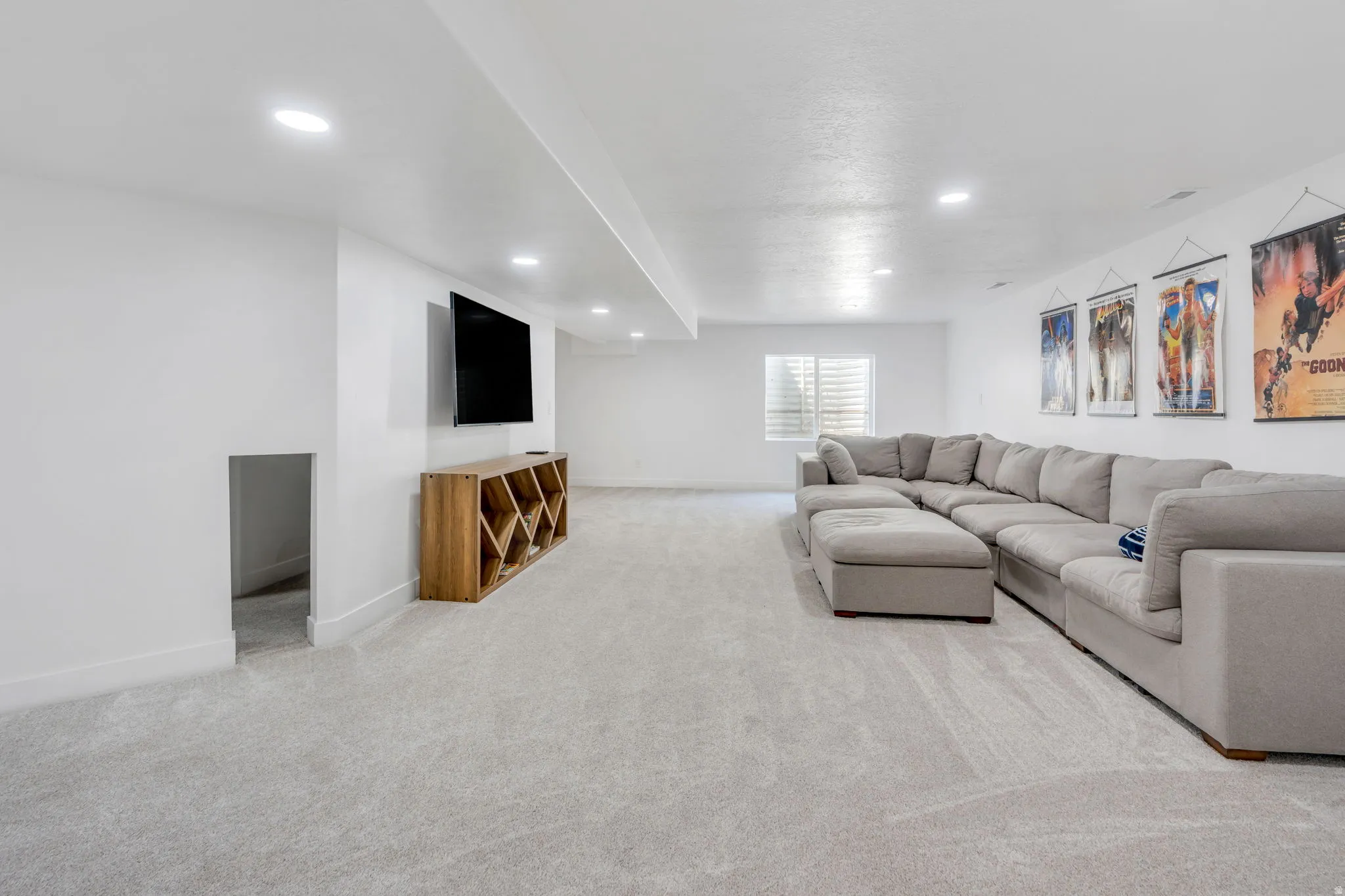 Spacious room with recessed lighting and light-toned carpeting