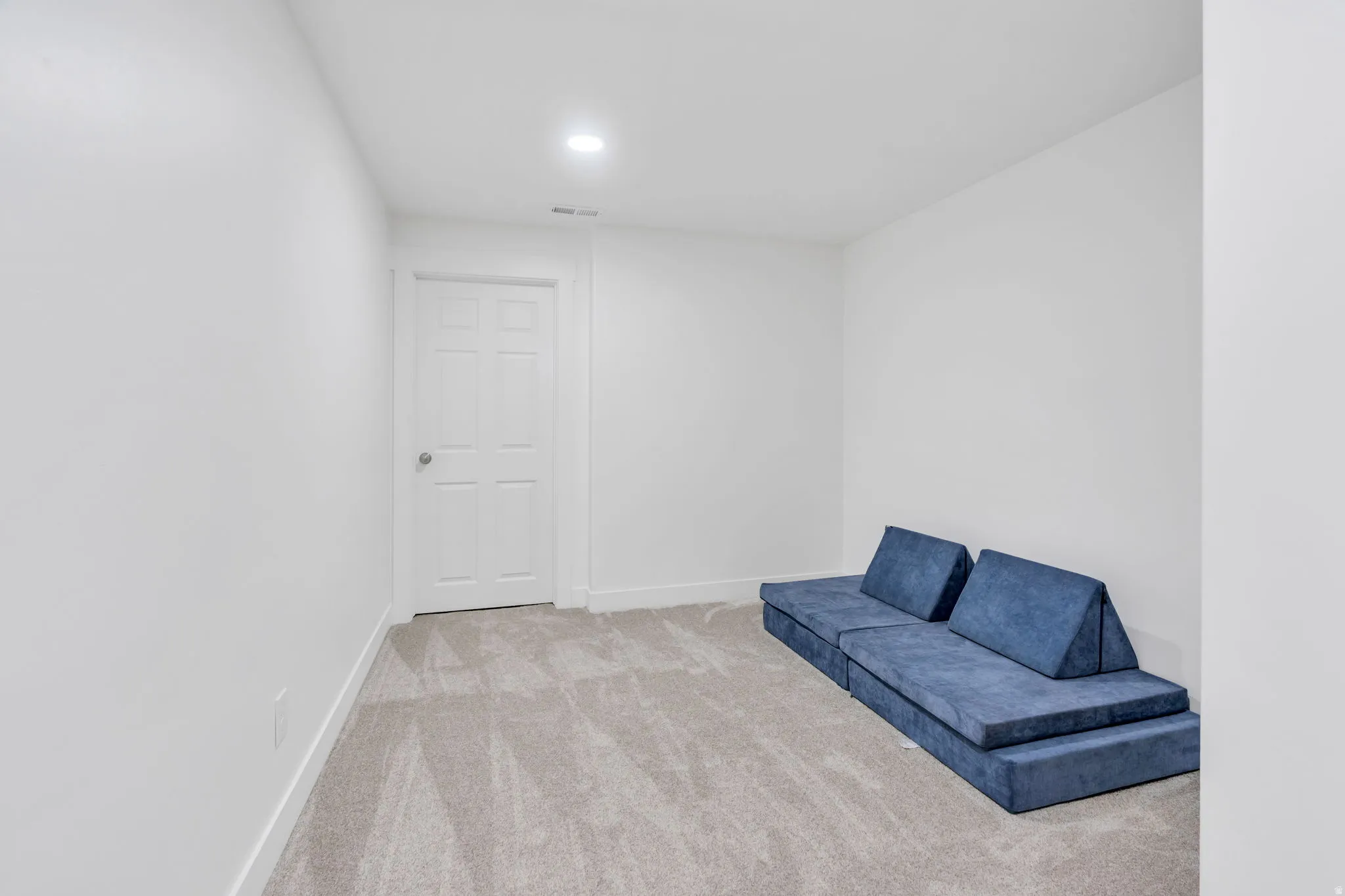 Finished basement recreation room featuring neutral plank-style flooring, recessed ceiling lighting, and smooth drywall walls