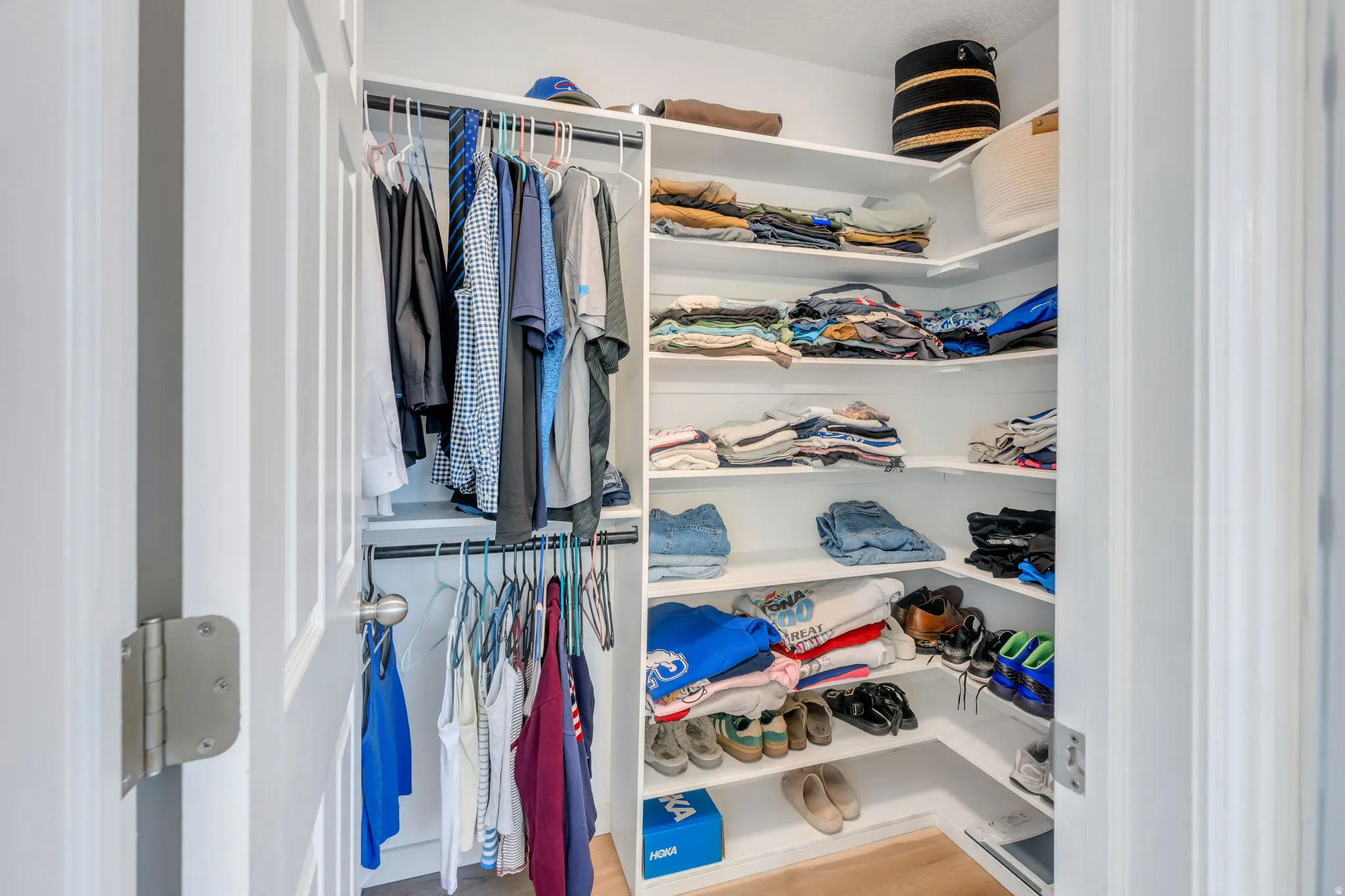 Spacious walk-in closet featuring custom shelving with multiple storage levels, hanging rod system for organized clothing storage, and built-in organizational solutions