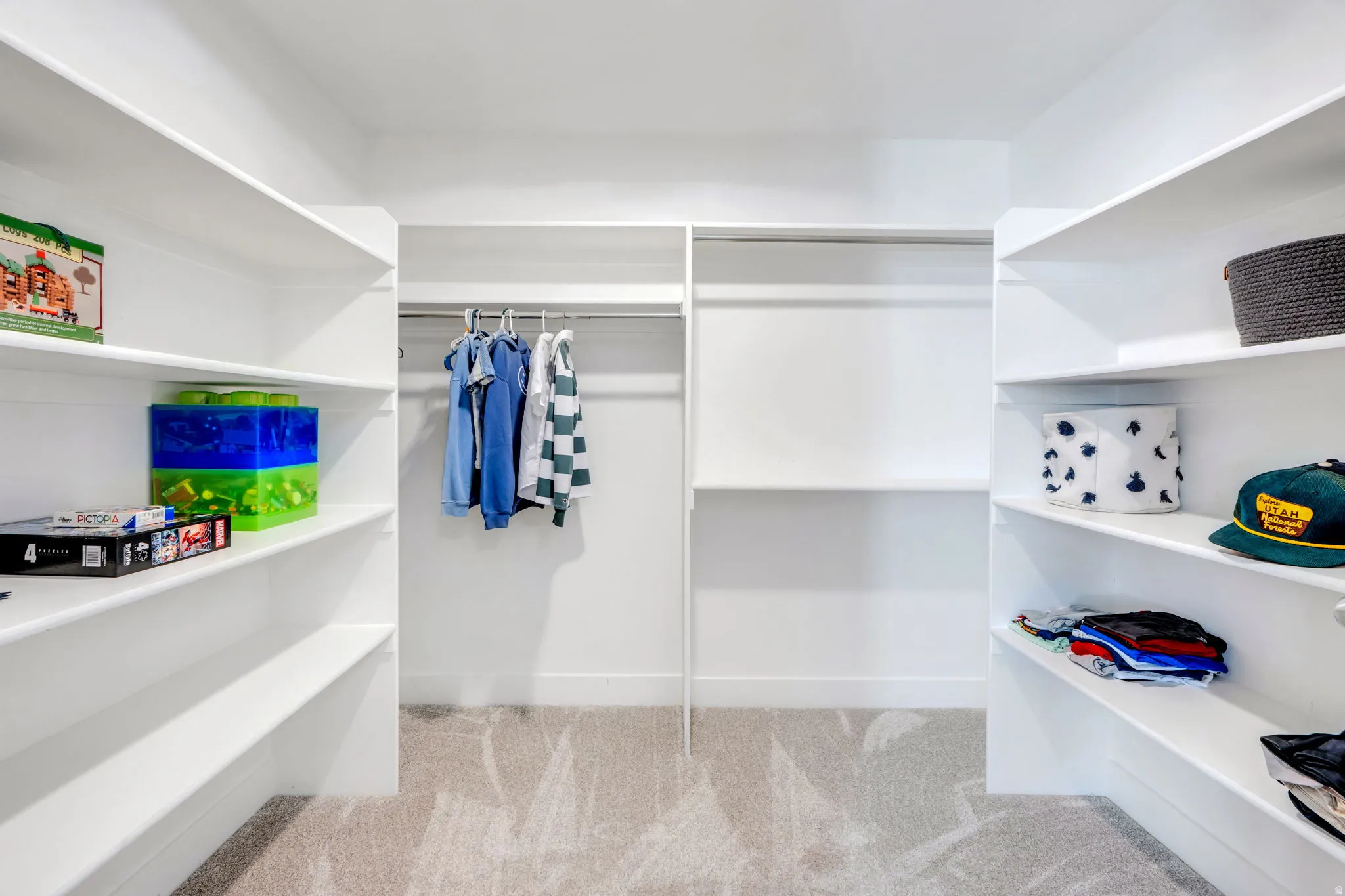 Organized walk-in closet featuring floor-to-ceiling white cabinetry with sliding glass doors, multiple shelving compartments, and integrated hanging rods