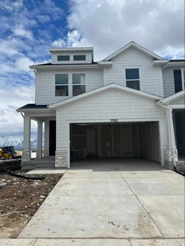 Contemporary exterior featuring white shake siding and stone accents