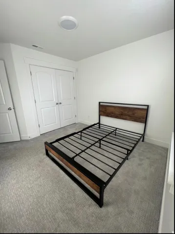 Carpeted room featuring a double-door closet, recessed ceiling lighting, and crisp white walls