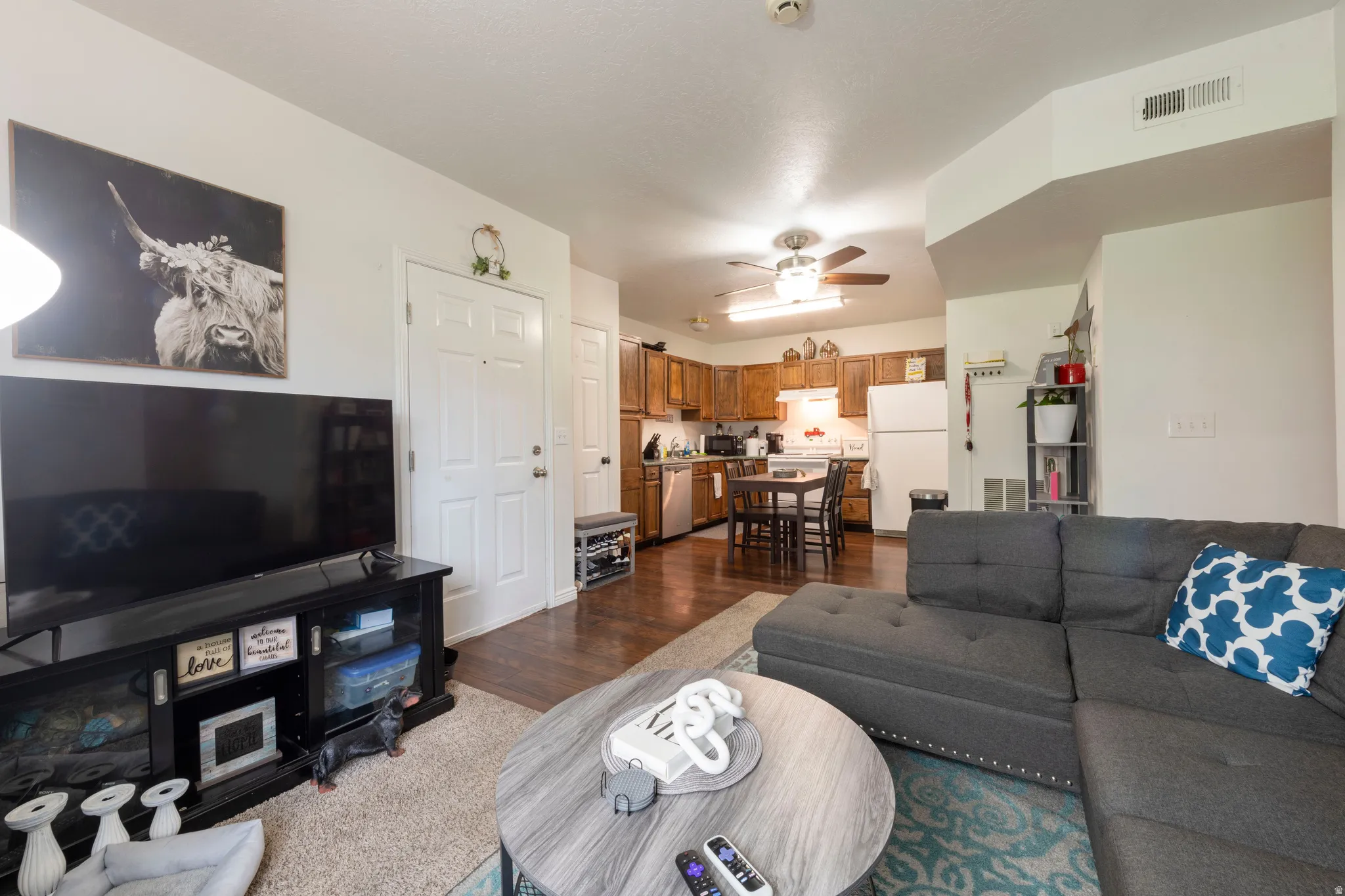 Open-concept living area with wood-finish flooring extending into the kitchen