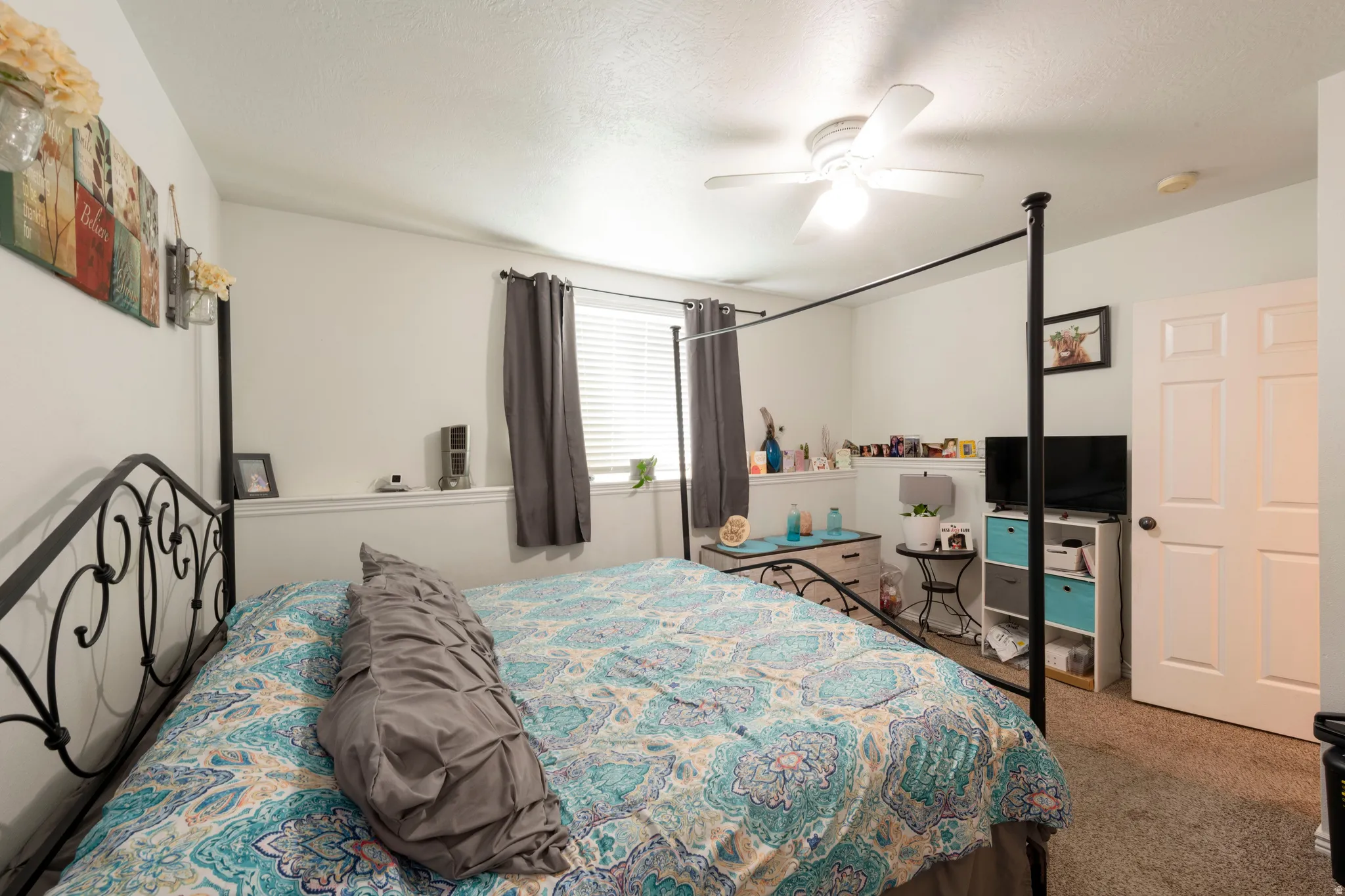 Interior room featuring neutral wall paint, a ceiling fan with integrated lighting, and a single window with horizontal blinds and drapery