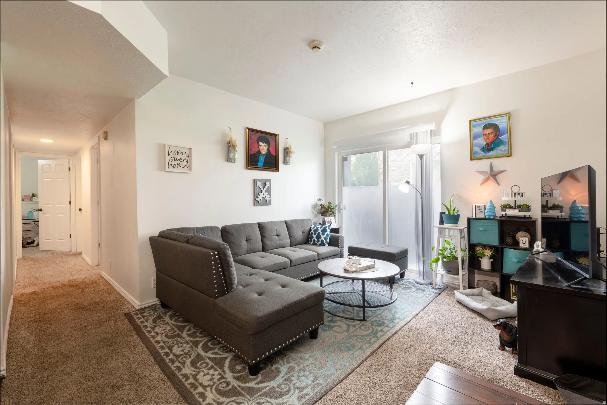 Bright living area featuring a sliding glass door with privacy film, white walls, and a recessed ceiling section
