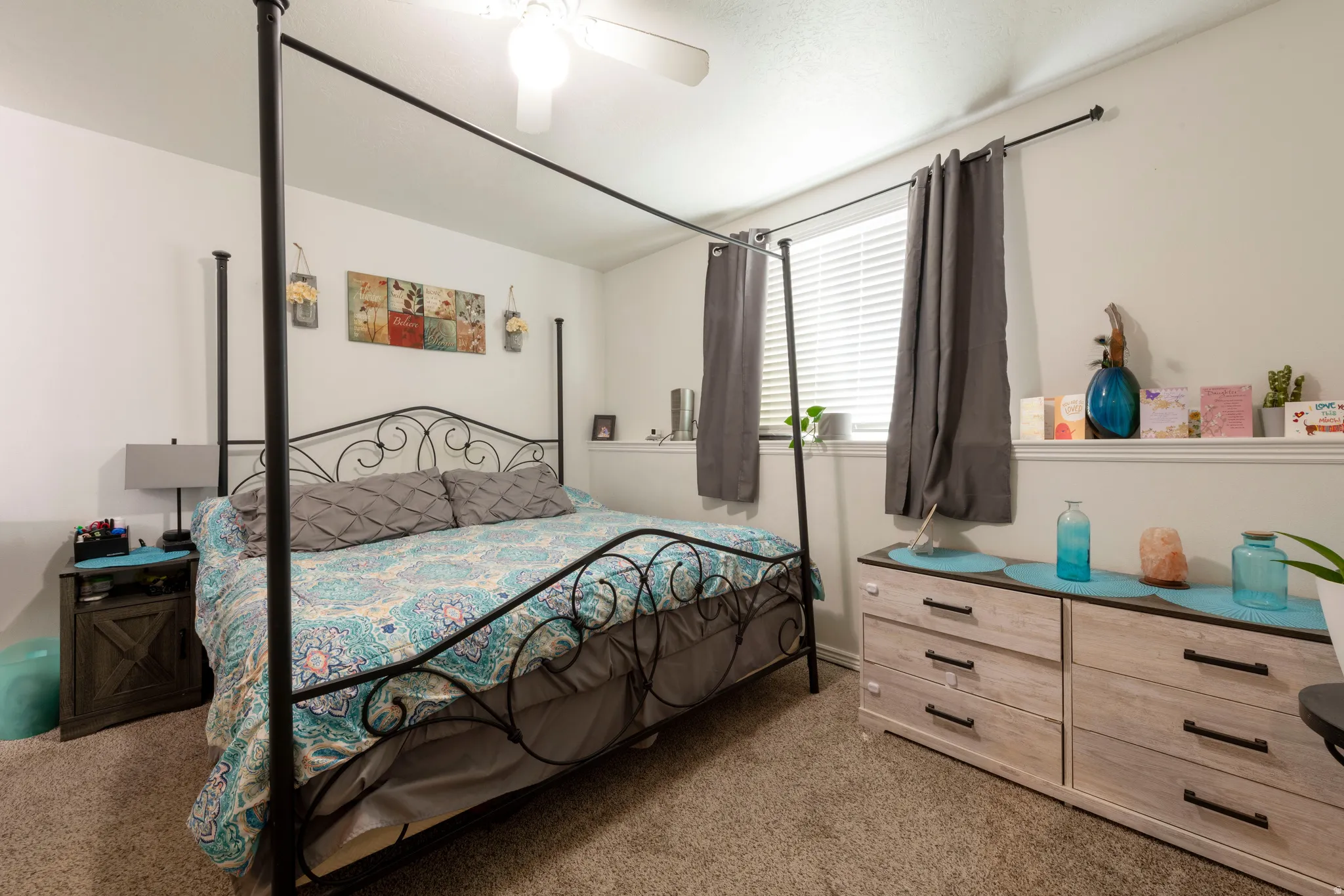 Carpeted room featuring a window with blinds, a built-in wall shelf, and a ceiling fan