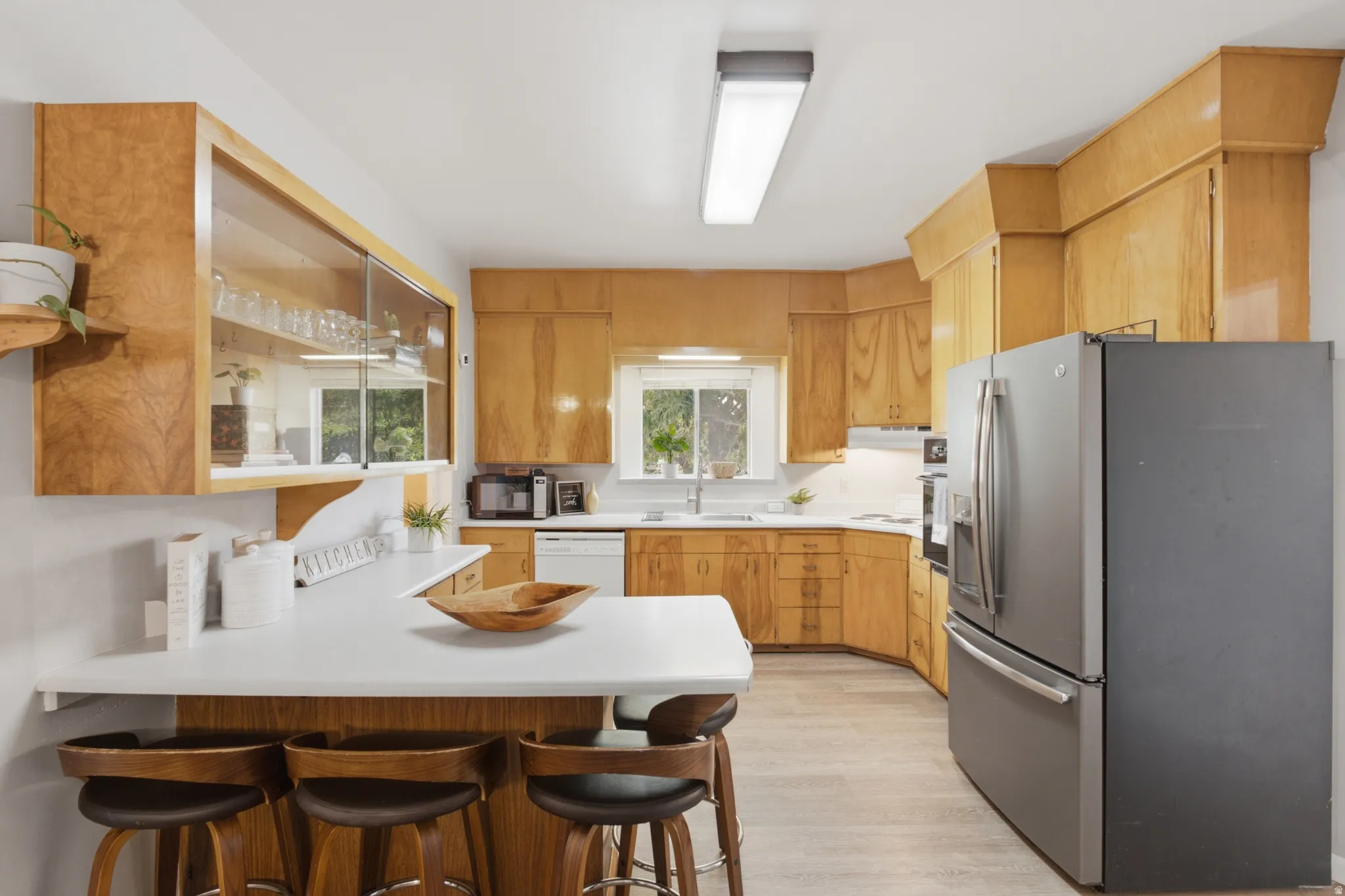Charming kitchen with built in glass cabinet above the kitchen peninsula.