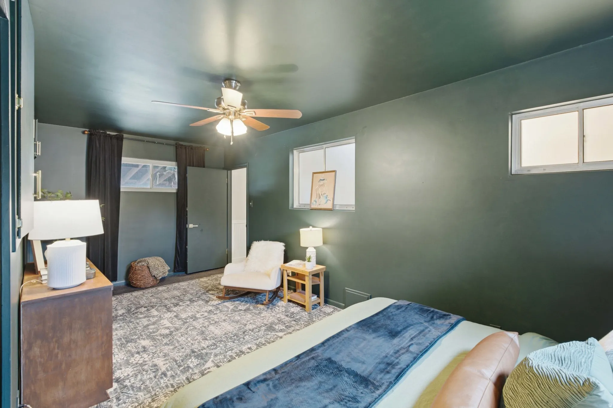Spacious room featuring dark walls, and multiple windows to allow for natural light.
