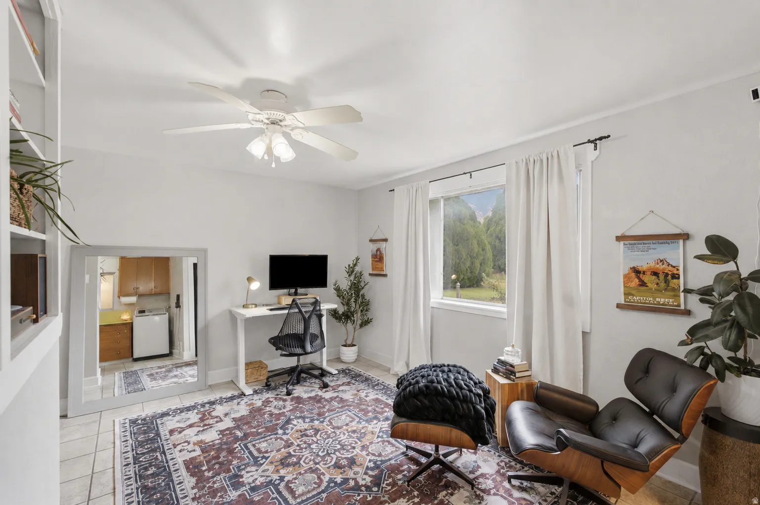 Bright interior space with built-in shelving, tile flooring, and a window with exterior tree views.