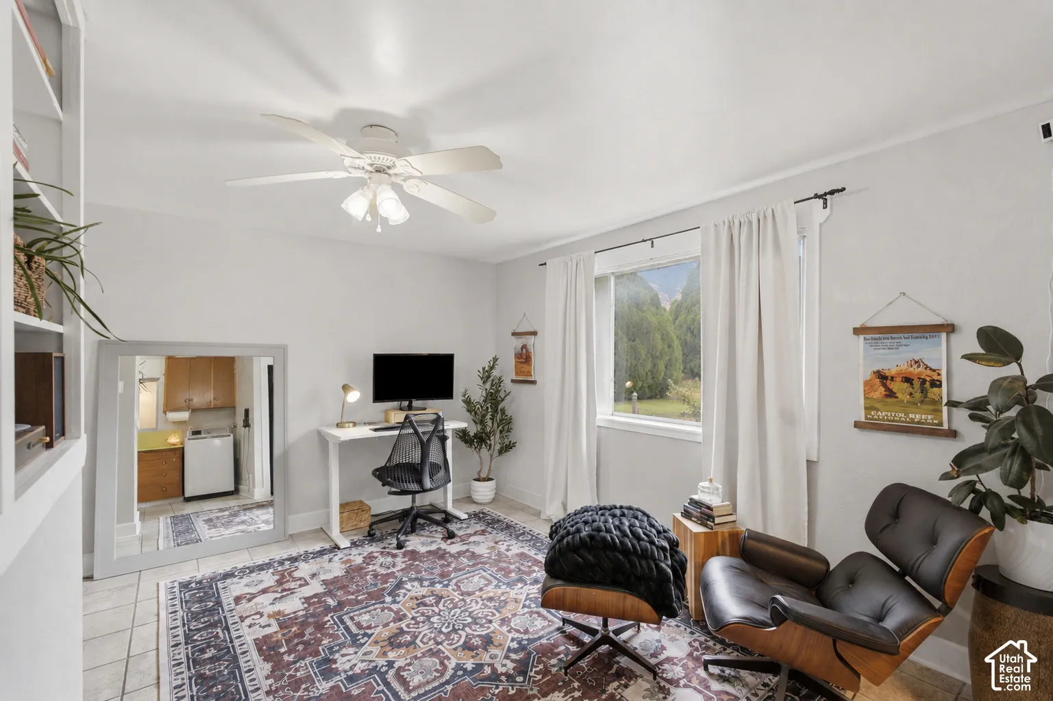 Bright interior space with built-in shelving, tile flooring, and a window with exterior tree views.