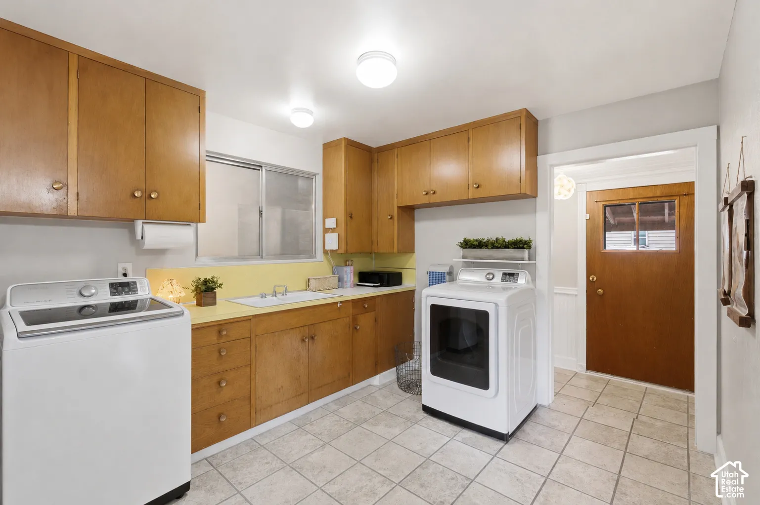 Large laundry room with cabinets offers plenty of room for storage.