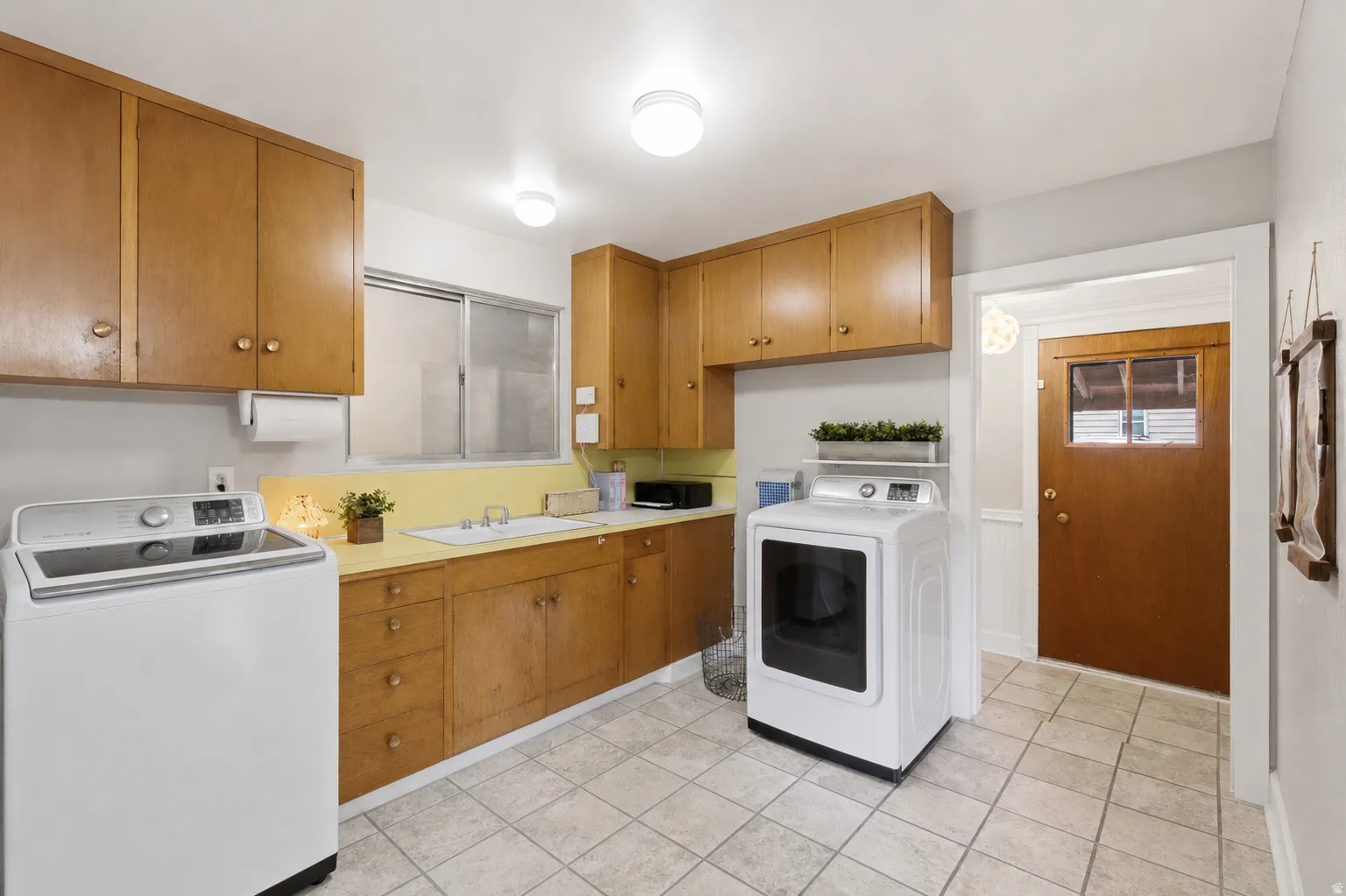 Large laundry room with cabinets offers plenty of room for storage.