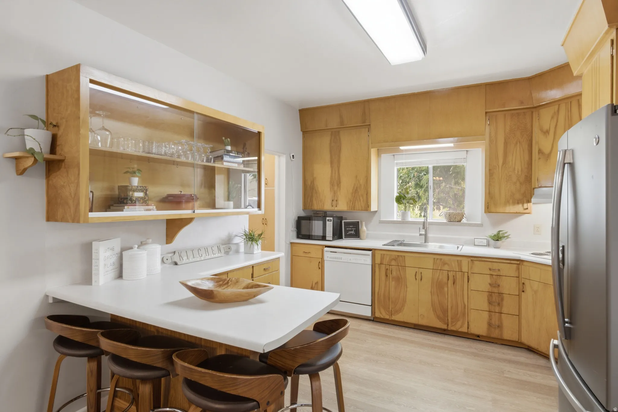 Kitchen featuring wood-finish cabinetry, white countertops, and wood-finish flooring.