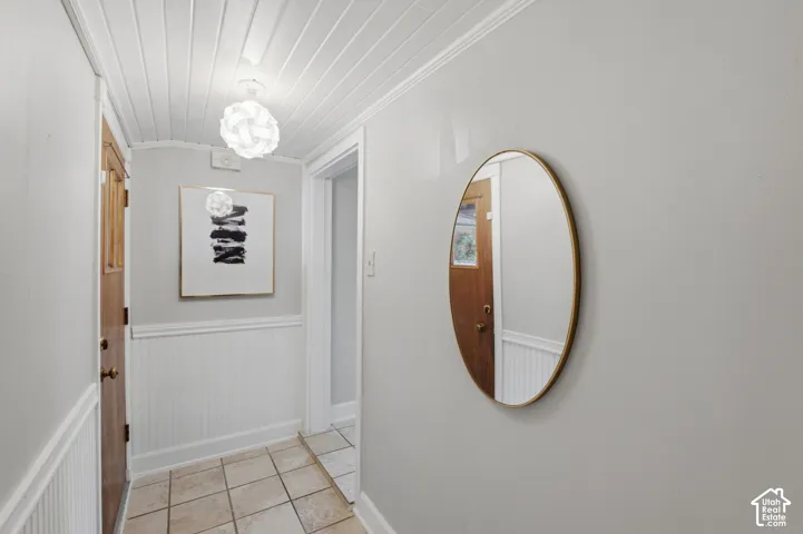Entryway featuring tile flooring, white wainscoting, and a white plank ceiling