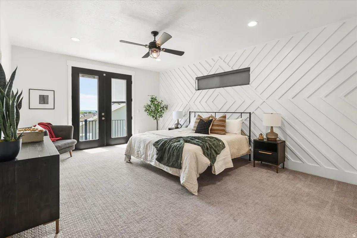 Room featuring a patterned accent wall, French doors with exterior balcony, recessed lighting, and a ceiling fan