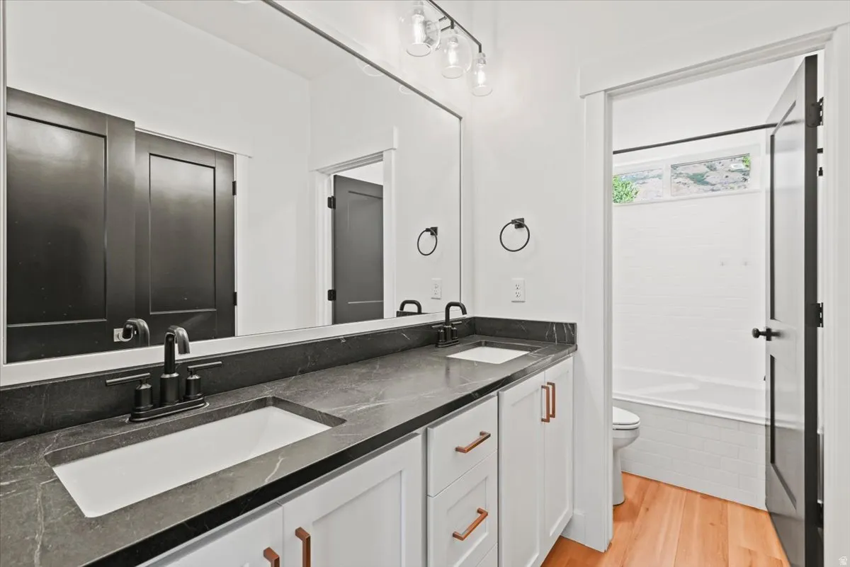 Bathroom featuring a double vanity with dark countertops and integrated sinks