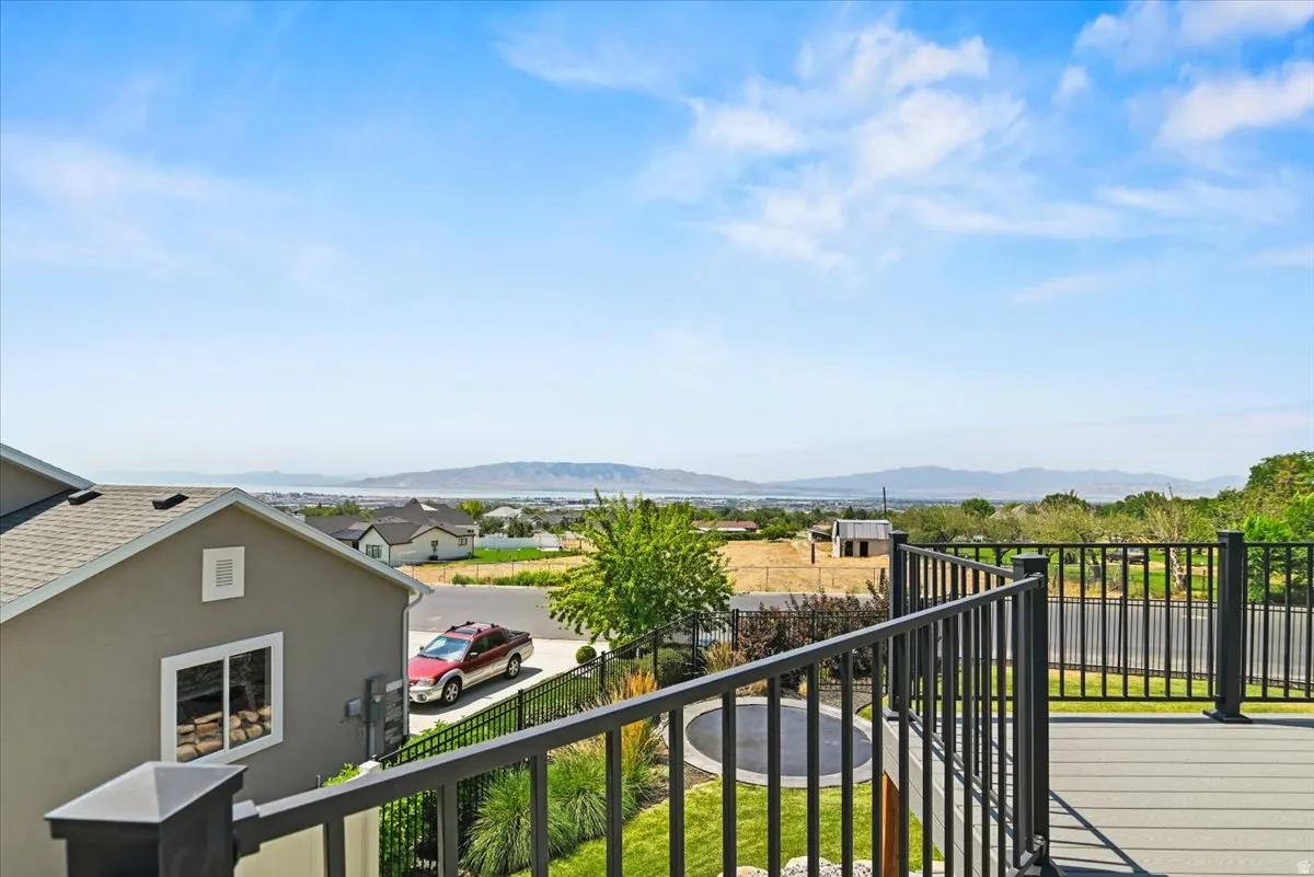 Elevated deck with black aluminum railings and composite decking, offering expansive vistas of rolling hills and distant mountain ranges