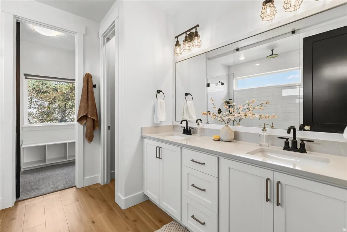 Double vanity featuring white shaker cabinetry, light-toned countertops, and matte black fixtures