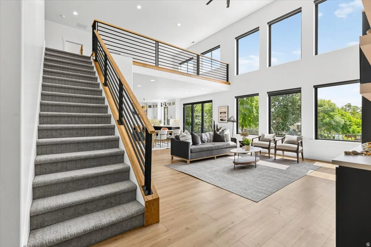 Open-concept living space featuring soaring ceilings with clerestory windows, wide-plank wood-finish flooring throughout, and abundant natural light