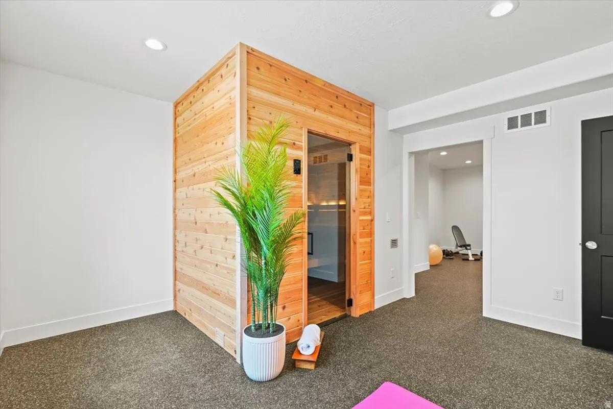Modern office or recreational space featuring a custom wood-clad sauna structure with glass door and interior bench seating